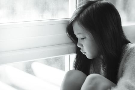 Portrait of asian beautiful sad girl at the window,vintage filterの写真素材