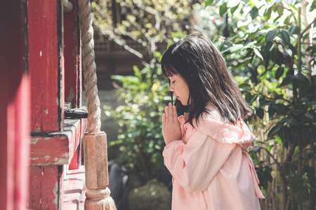 Beautiful asian girl is praying at the shrine,vintage filterの写真素材