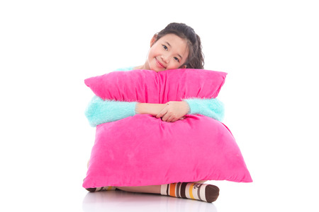 Beautiful asian girl with a big pink pillow on white background isolatedの写真素材