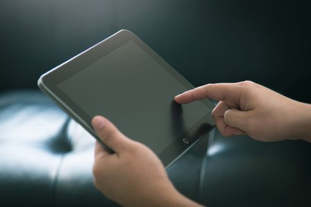 Close-up of hands touching digital tabletの写真素材