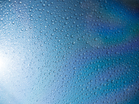 Blue water drops on mirror background