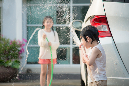 Asian children washing car in the gardenの写真素材