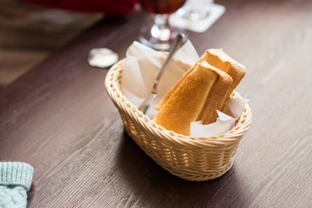 White toasted bread in basket on wooden tableの写真素材