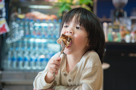 Cute Asian boy eating honey toastの写真素材