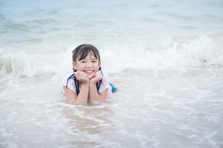 Beautiful Asian girl ying on the breachの写真素材