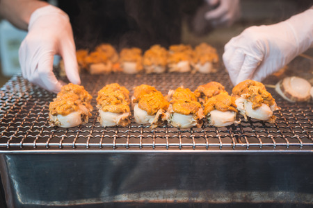 Scallop and sea eggs skewer grill with smoke, japanese street food ,Tsukiji Fish Market Tokyo Japanの写真素材