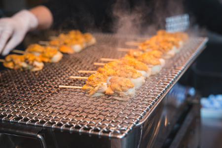 Scallop and sea eggs skewer grill with smoke, japanese street food ,Tsukiji Fish Market Tokyo Japanの写真素材