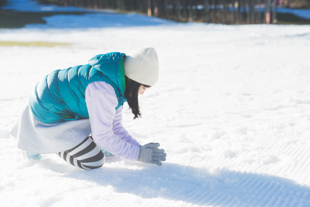 Happy asian girl smiling outdoors in snow on cold winter dayの写真素材