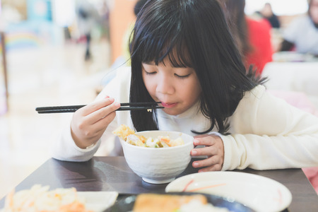 Beautiful Asian girl eating Tempura Rice Bowlの写真素材