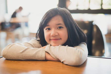 portrait of beautiful Adsian girl smiling in a coffee shopの写真素材