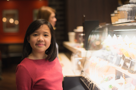 Asian girl choosing ice-cream in the glass caseの写真素材