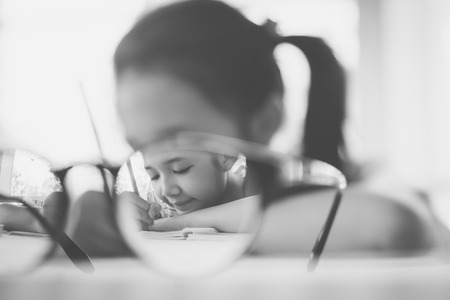 Beautiful asian girl writing to diary on the tableの写真素材
