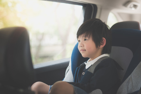 Portrait of cute Asian child sitting in car seatの写真素材