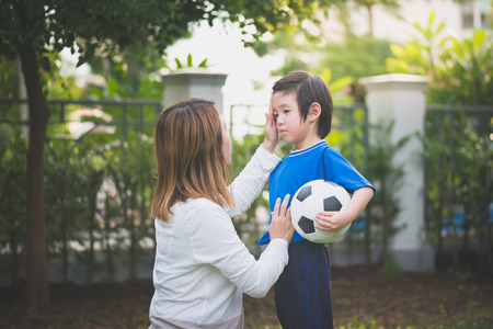 Asian mother and son Playing Soccer In Park Togetherの写真素材