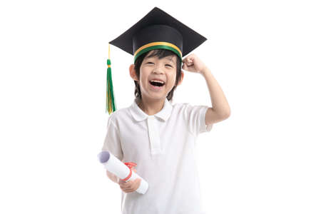 Happy Asian child in graduation gowns holding a Certificate on white background isolated.Graduation conceptの写真素材