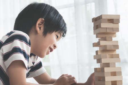 Cute Asian child playing wood blocks stack gameの写真素材
