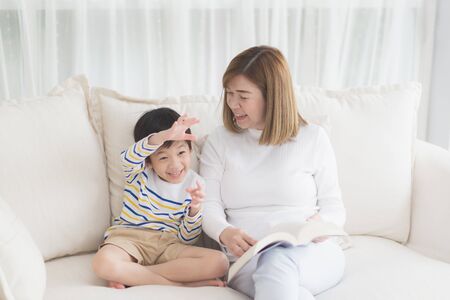 Asian mother Sitting With Son Reading Story togetherの写真素材