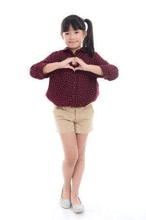 Beautiful asian girlshowing heart with two hands on white background isolatedの写真素材