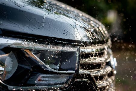 Splash of water on the black carの写真素材