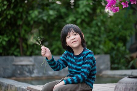Portrait of Cute Asian boy sitting in the parkの写真素材