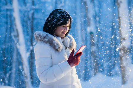 Beautiful Asian short hair girl with a mobile phone in winter night