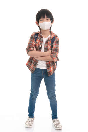 Cute Asian student wearing mask and carrying schoolbag isolated on white backgroundの写真素材