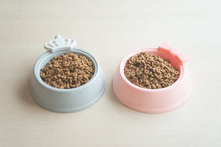 Close up of dry dog food in bowl on wooden tableの写真素材
