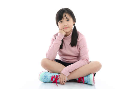 Beautiful asian girl sitting on white background isolatedの写真素材