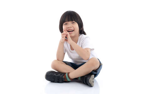 Happy Asian child sitting on white background,isolatedの写真素材