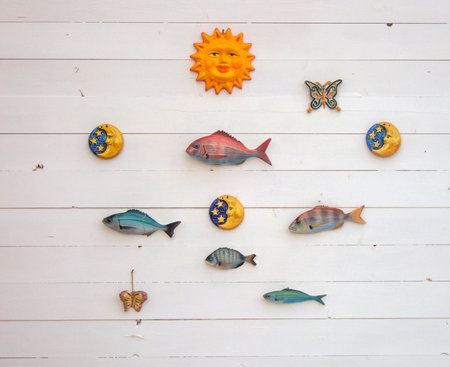 Colorful fish on the white wooden wall backgroundの写真素材