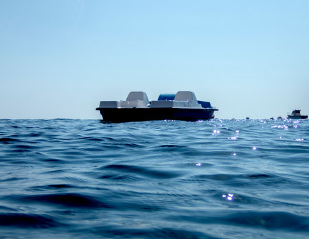 Pedal boat in the sea with blue sky and water reflection background.の写真素材