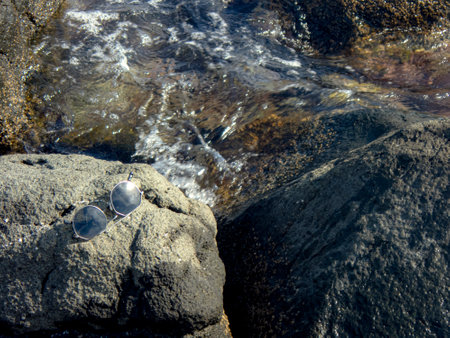 Sunglasses on a rock by the sea, Selective Focus
