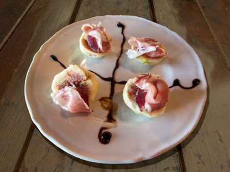Antiposto with ham and figs on wooden table