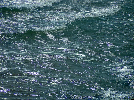 Blue sea water with waves and foam as a background. Textures.