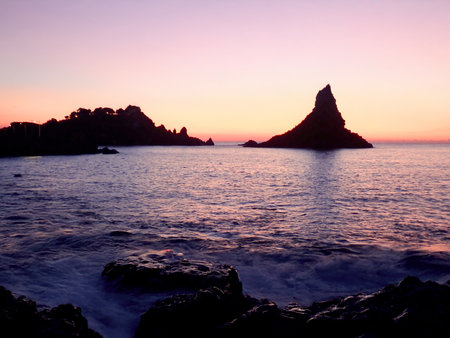 The Faraglioni of Acitrezza and Lachea Island in Silhouette at Duskの写真素材