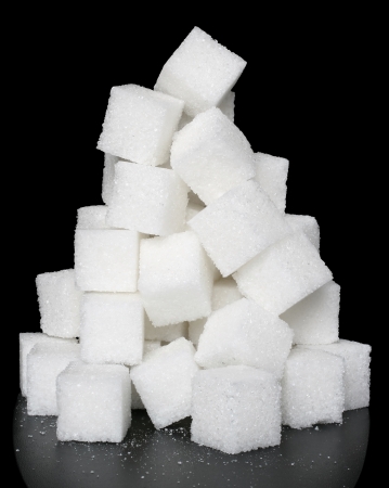 Heap lump sugar with reflection on a black background.の写真素材