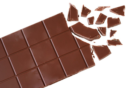 Bar of chocolate with broken cubes isolated on white background top view.の写真素材