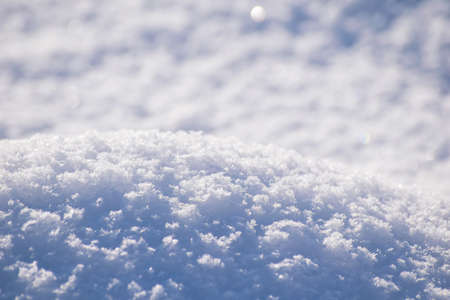 Macro background of fresh snowflake texture on a blur.