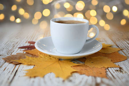 Ð¡up of coffee with autumn leaves on a wooden tableの写真素材