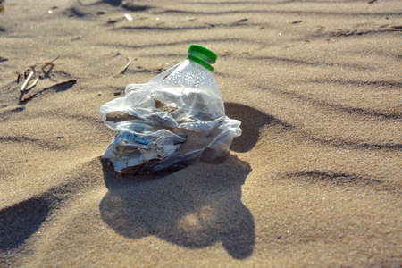Plastic bottle pollution on a sandy beach.
