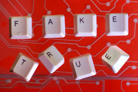 Keyboard keys form the word FAKE TRUE on red electric circuit in the background.