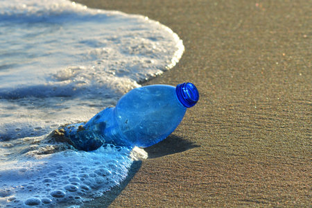 Plastic bottle pollution on a sandy beach.