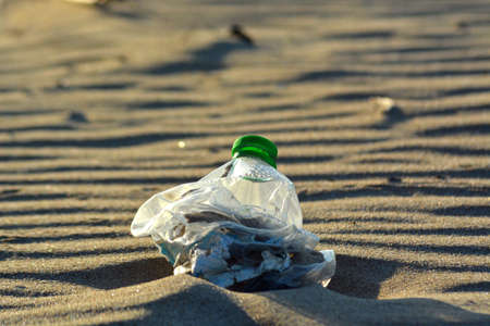Plastic bottle pollution on a sandy beach.の写真素材