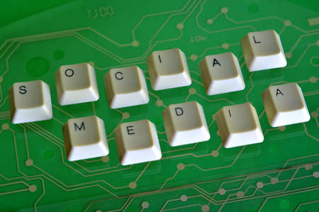 Keyboard keys form the word SOCIAL MEDIA on green electric circuit in the backgroundの写真素材