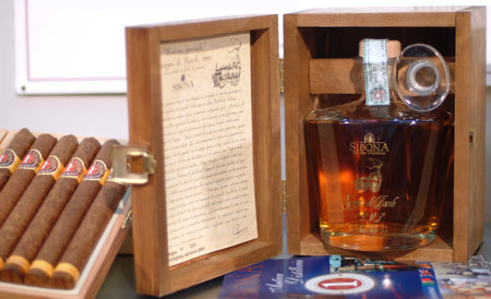 Turin, Piedmont, Italy -10-24-2009- The "Wineshow Fair". Bottle of aromatic Grappa and box of cigars.のeditorial素材