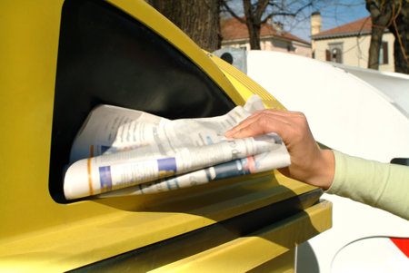 Detail of a female hand disposing of paper in a proper container with palace in the backgroundのeditorial素材
