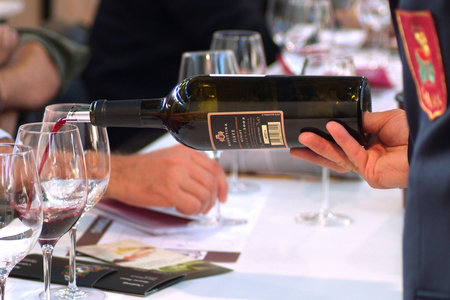 Turin, Piedmont, Italy. -10-26-2009- Fair "Wine show" sommelier pouring red wine to taste.のeditorial素材