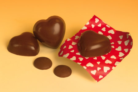 Italian food product, heart shaped milk cocoa chocolates on orange background.の写真素材