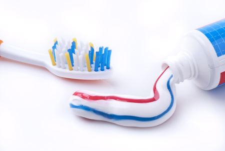 toothbrush with toothpaste tube in closeup on white background