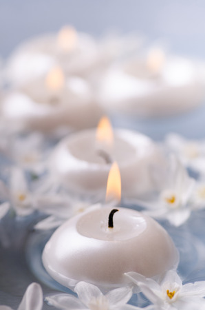 close-up with the flame of some floating candles and white daffodil flowers.の写真素材